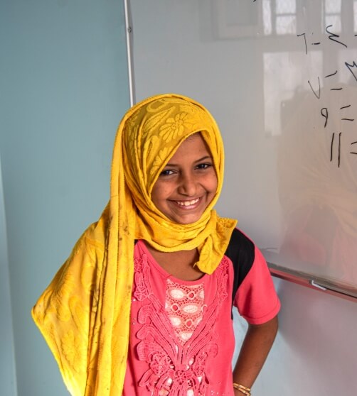 student smiling in front of a white board
