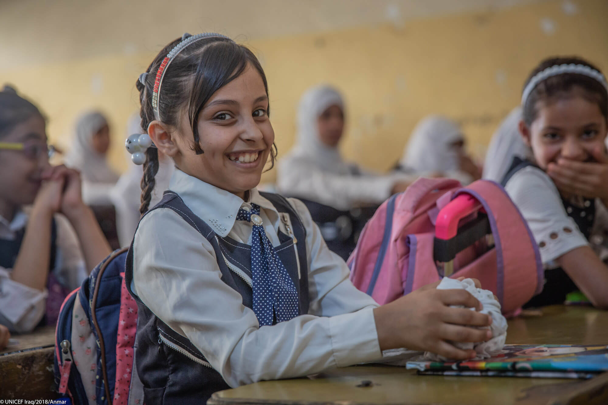 student sitting at her desk smiling