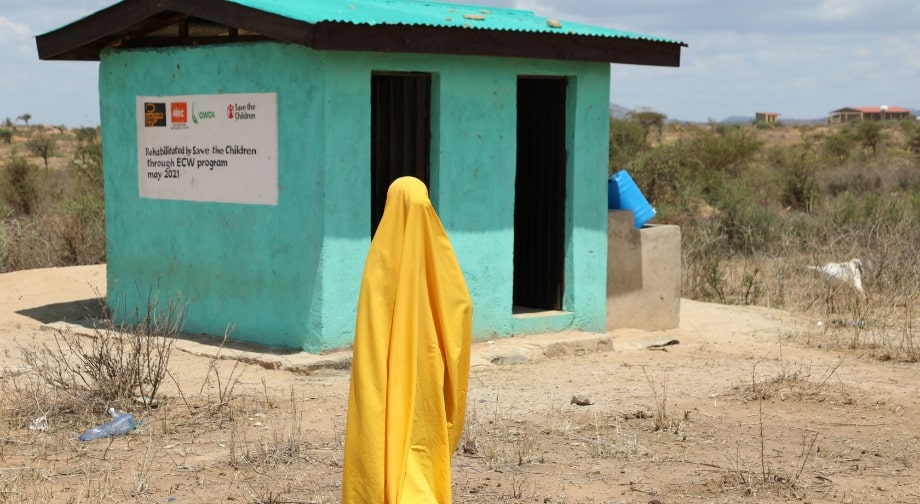 Hanifa standing outside next to a building