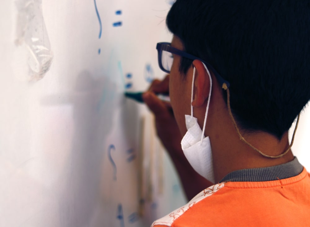 Rafat writing on the whiteboard in his classroom