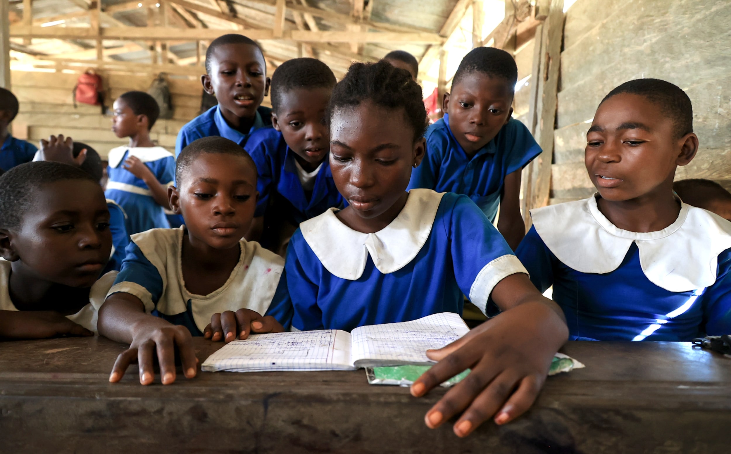 A group of students around a table looking at a notebook