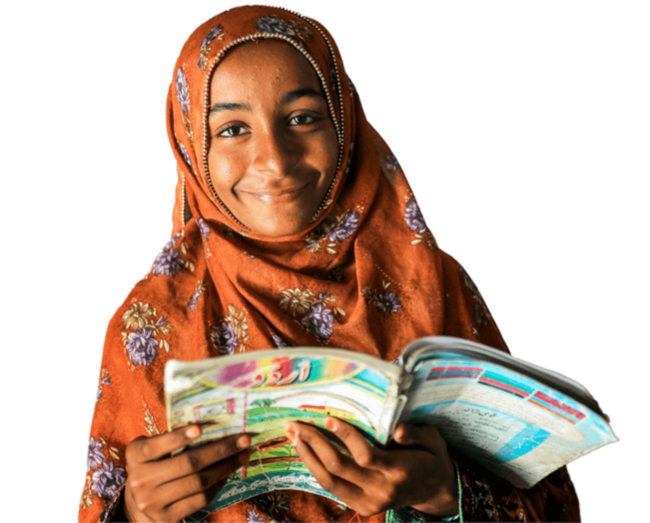 a girl in orange floral patterned clothing and head scarf. she is holding a workbook and smiling