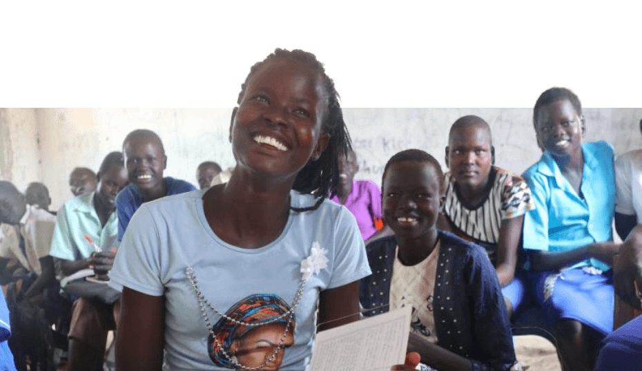 ajak smiling in her classroom holding a notebook