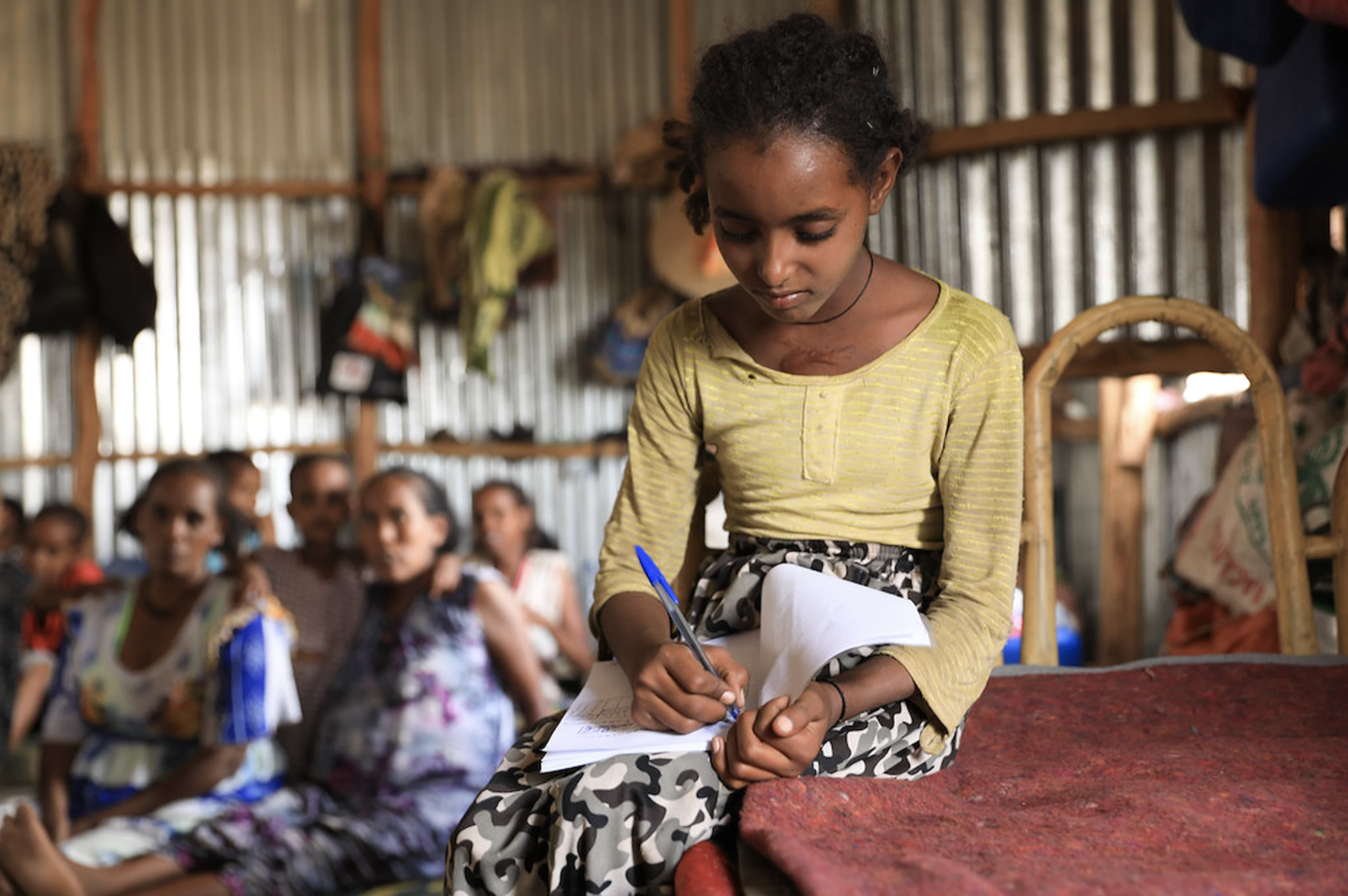 Girl attending class writing on a notebook