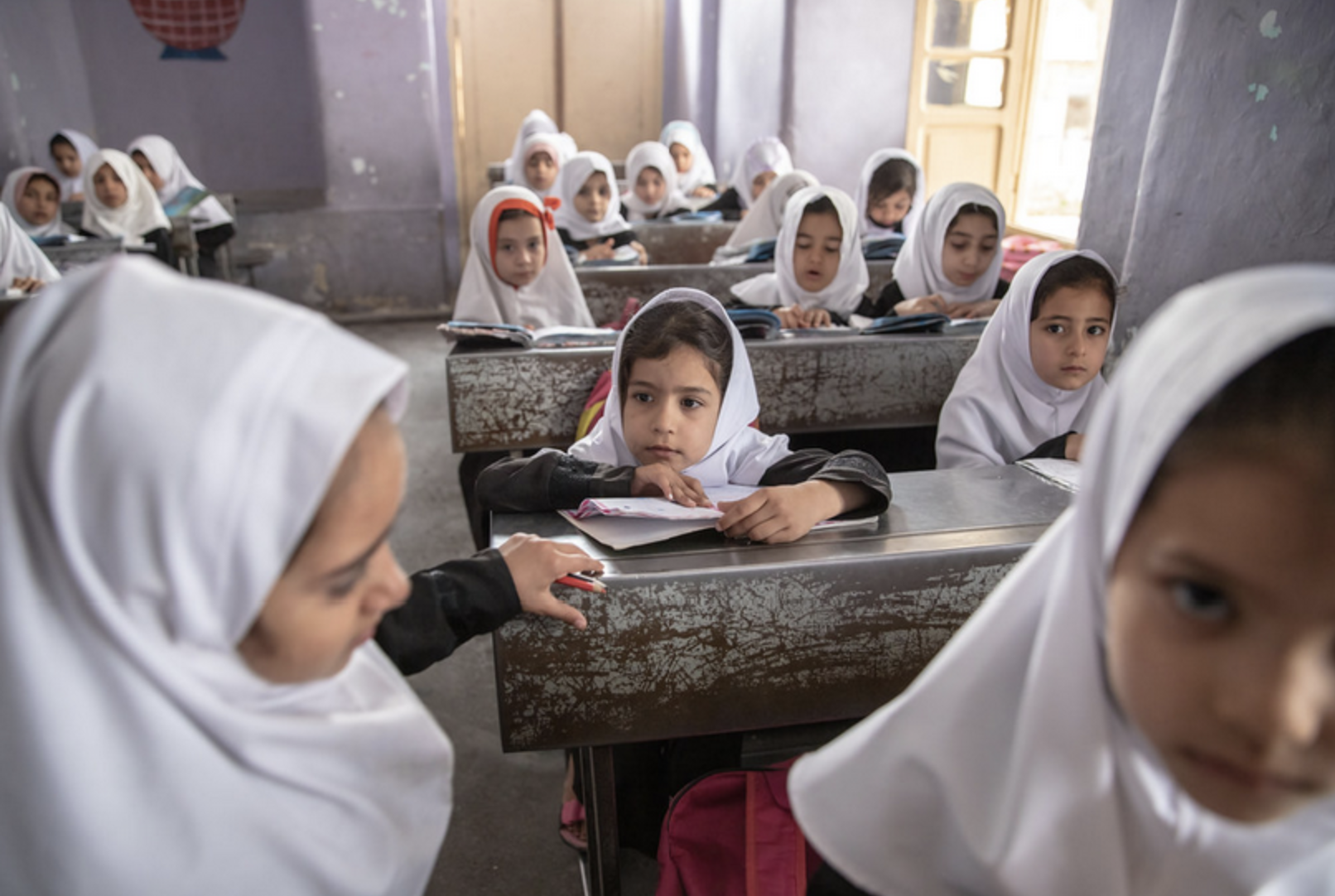 Group of girls sitting on their desks attending class