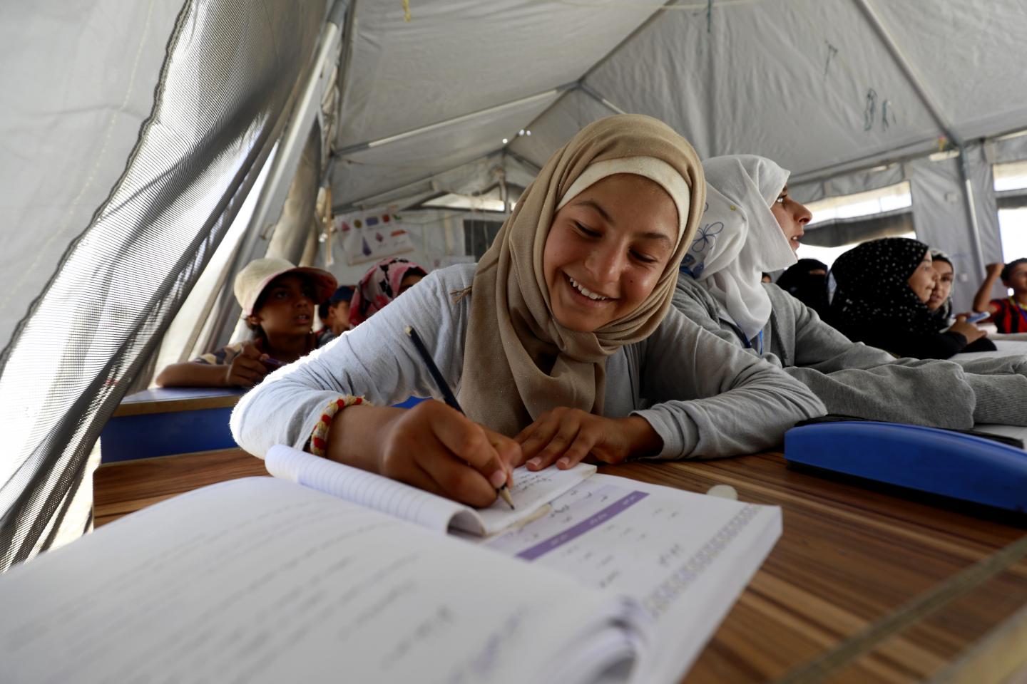 Girl attending class writing on her notebook