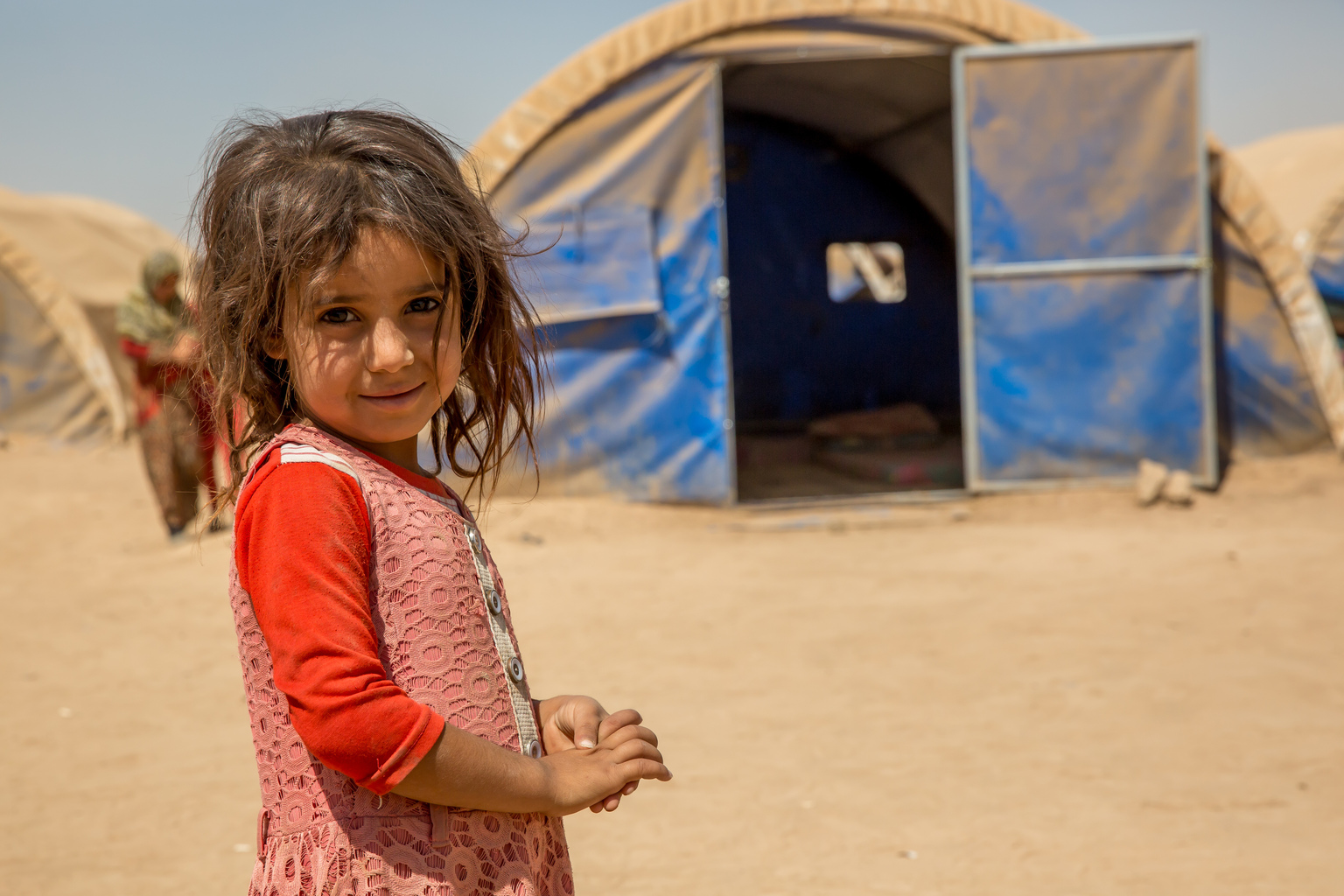 Girl stands in displacement camp.