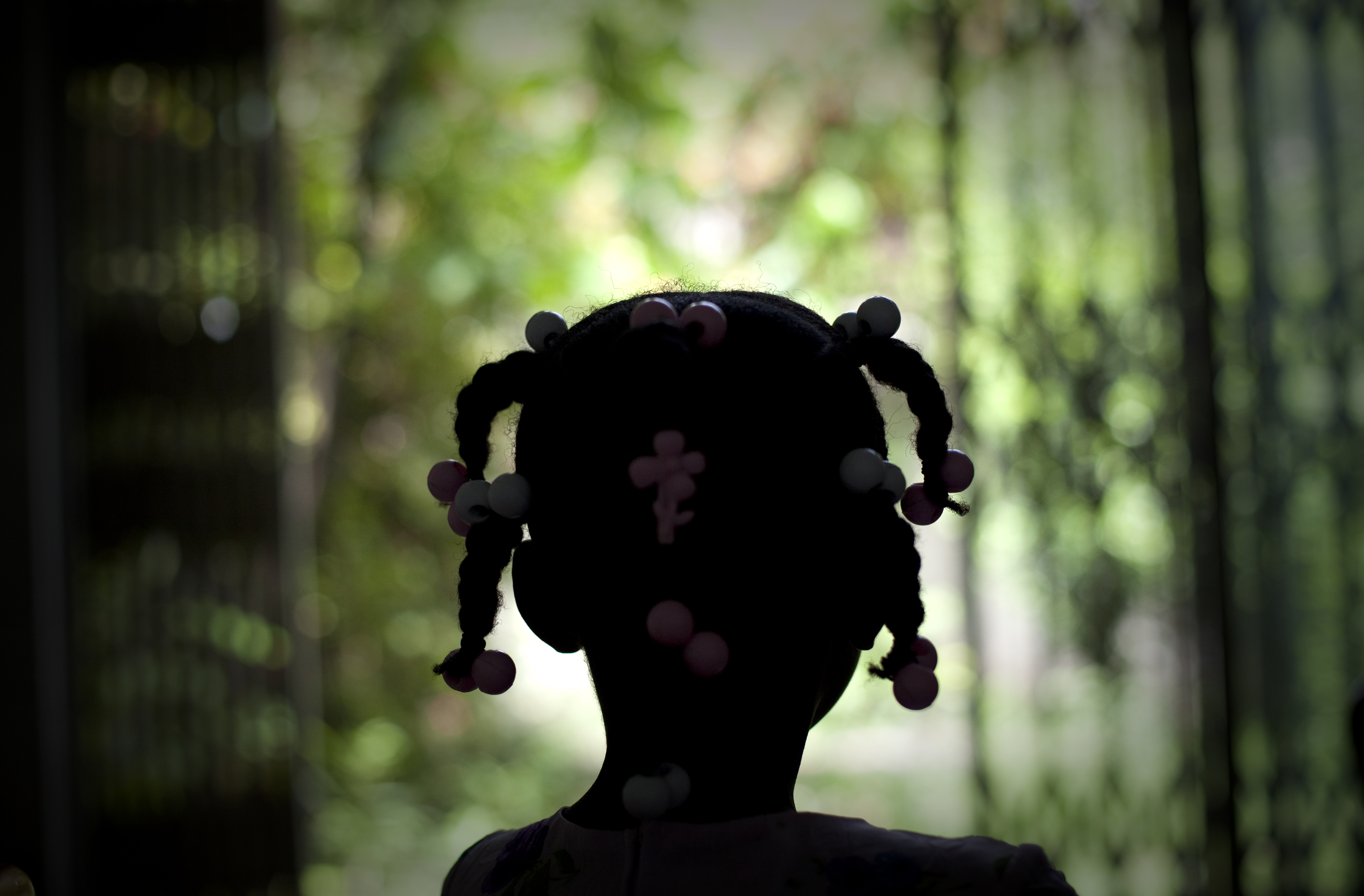 Young girl from Haiti with her back to the camera.