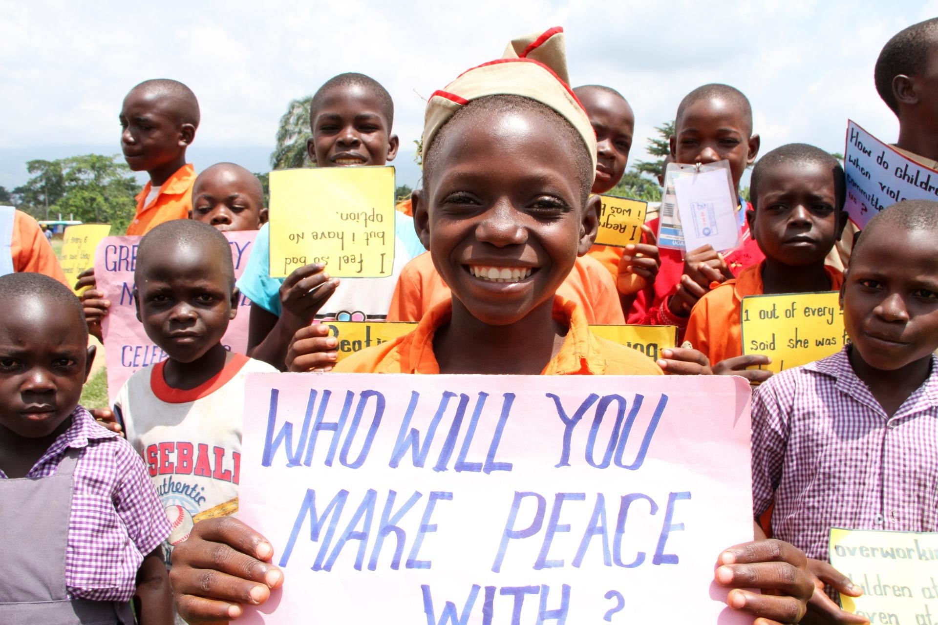 An African girl holding a sign "Who will make peace with"