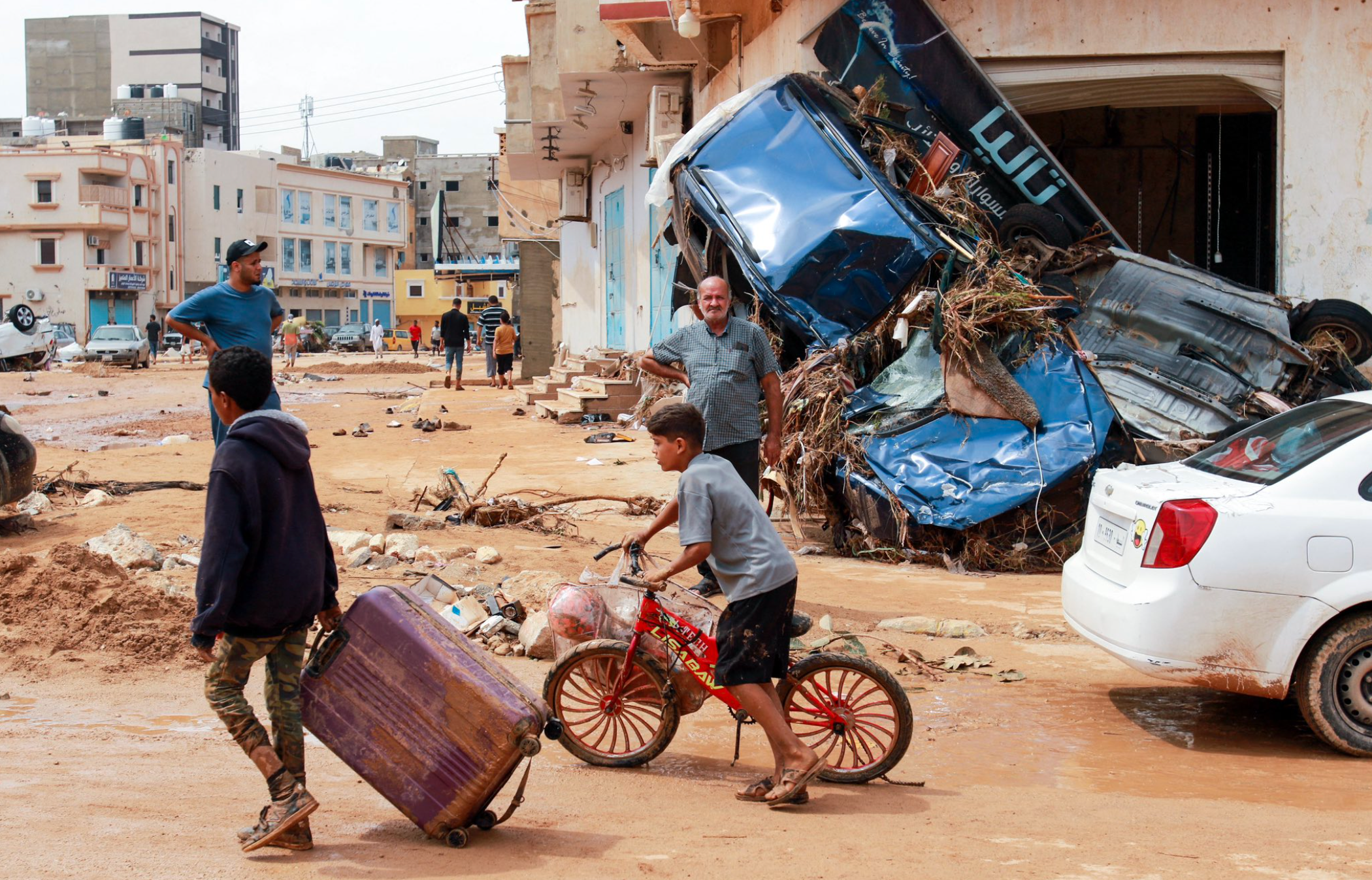 Child rides his bike during flooding in Libya.