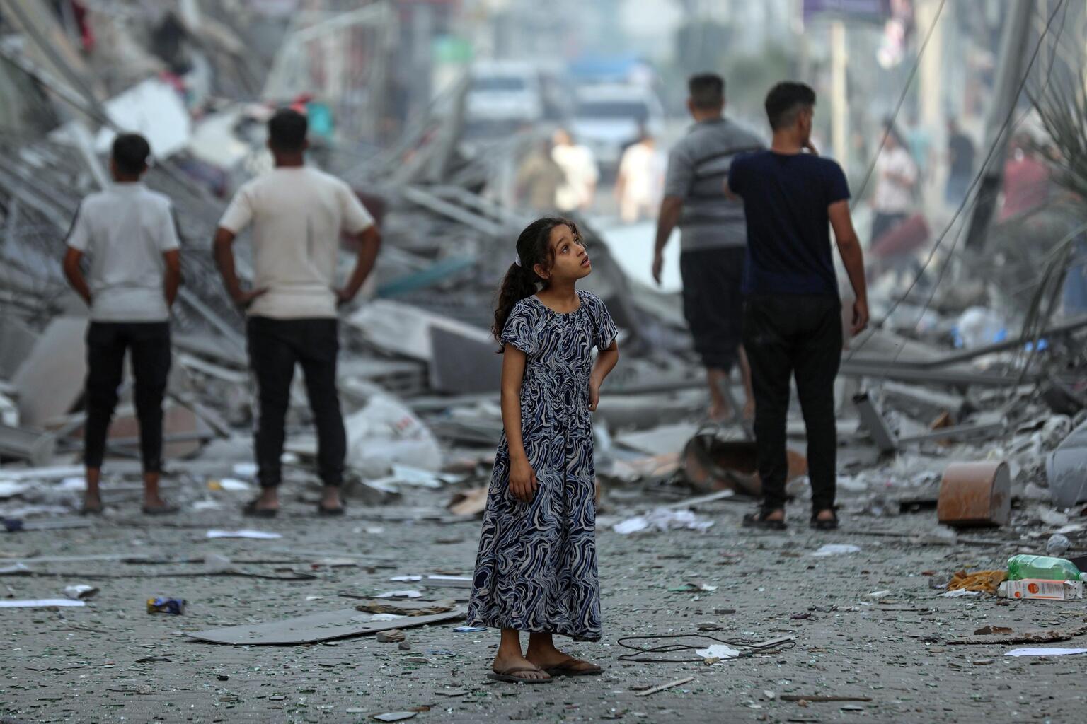 Palestinian child in the street amidst the wreckage of homes destroyed by airstrikes in the Gaza Strip