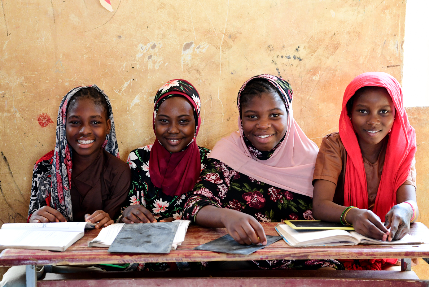Girls inside a classroom smiling