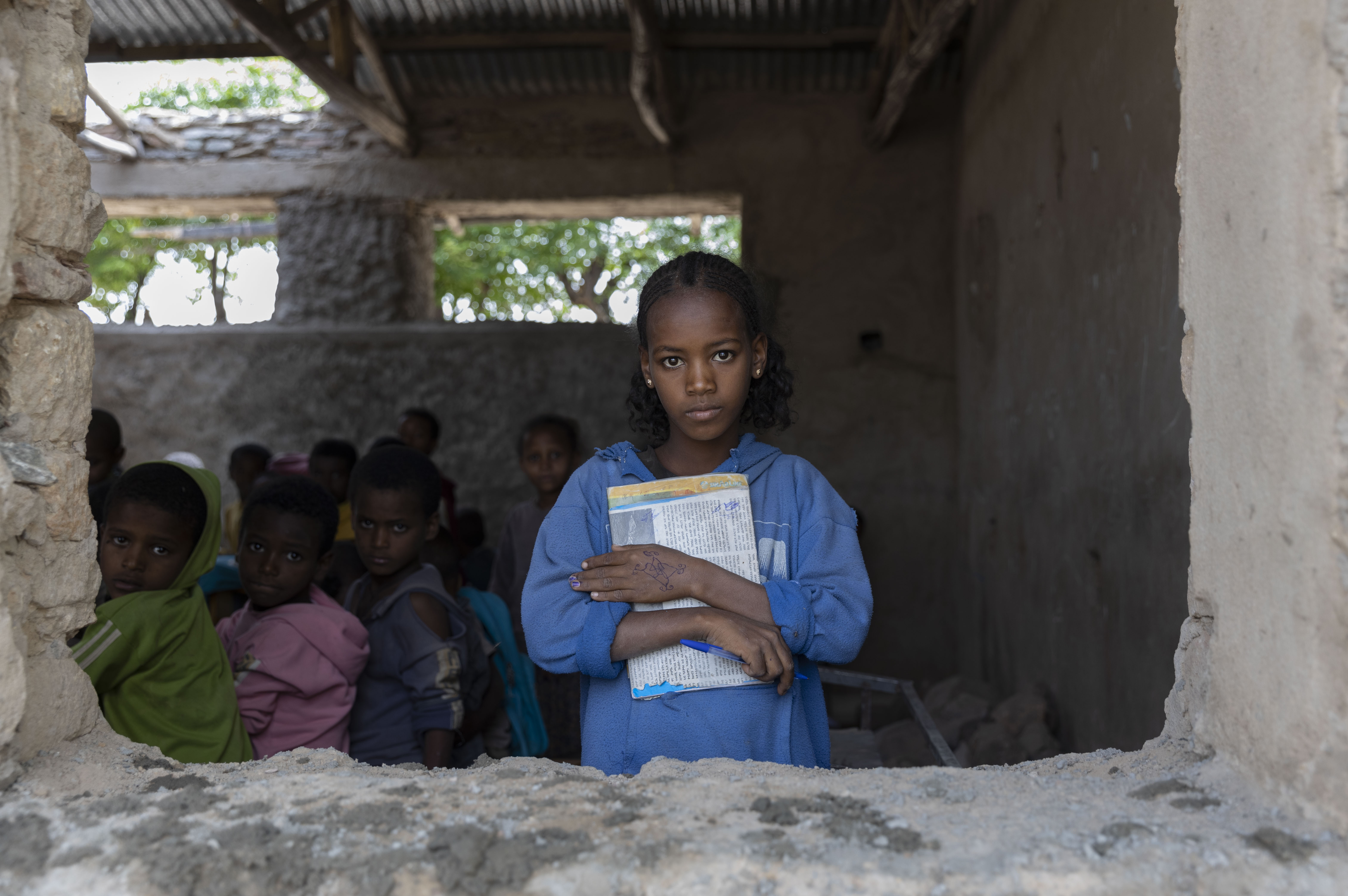 Girl inside a classroom holding a book