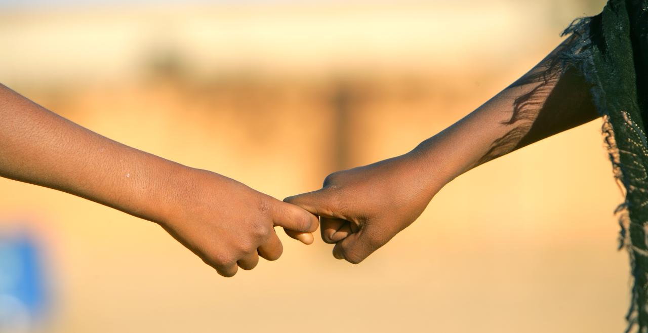 Photo of 2 children holding hands