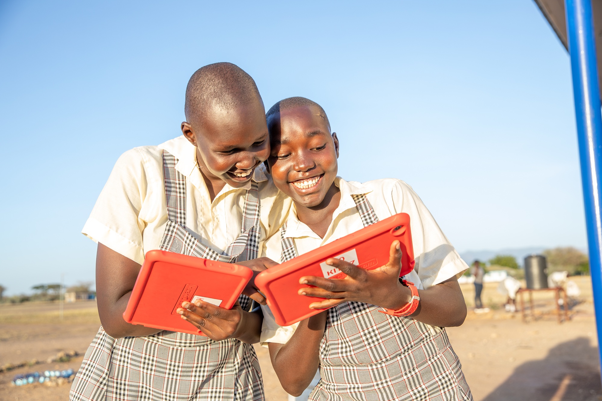 2 schoolgirls holding a tablet