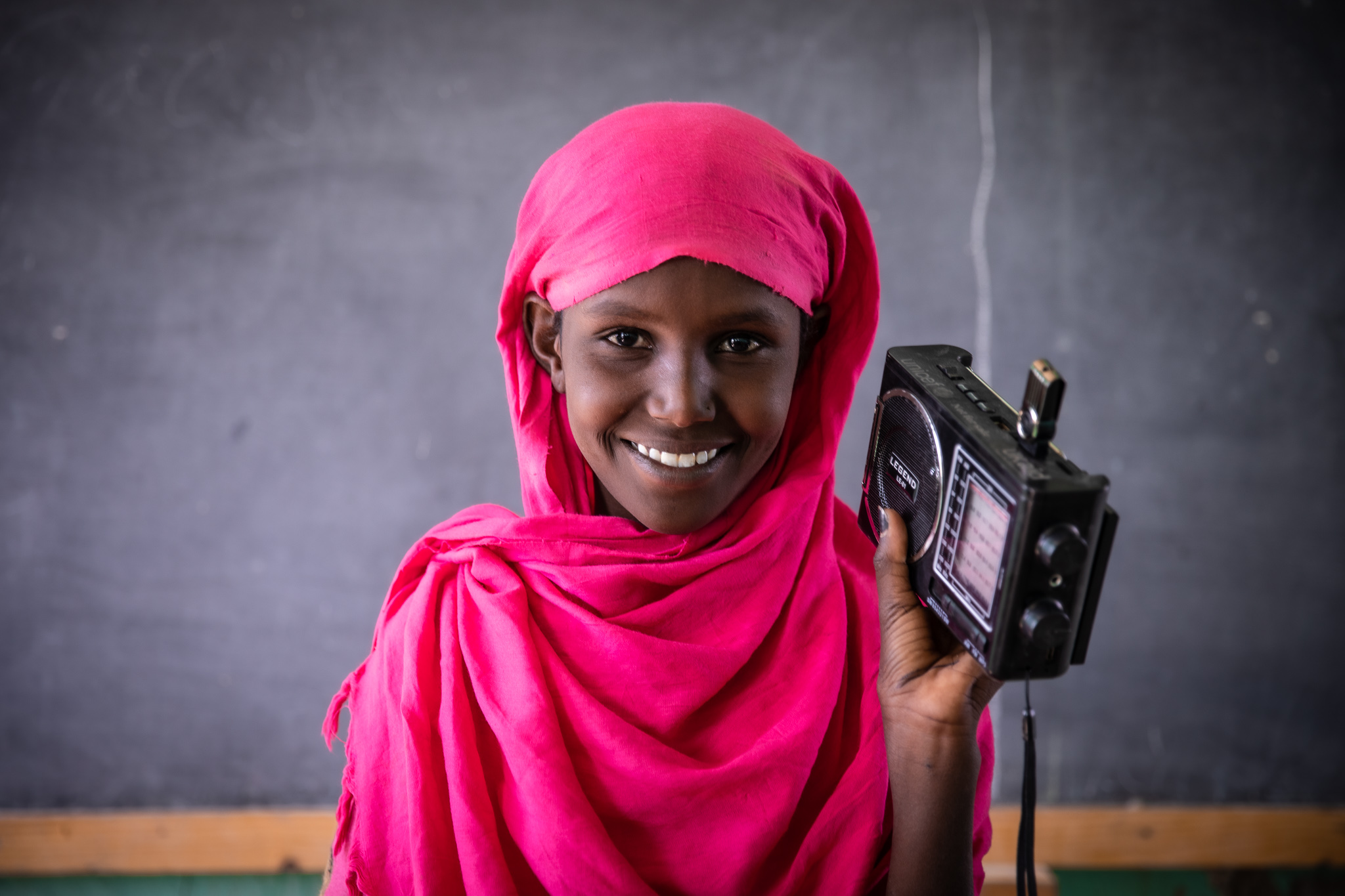 Girl holding a radio in a classroom