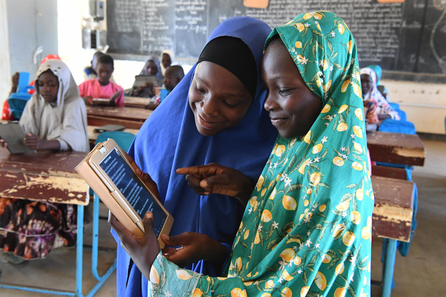 Girls at school interacting with an iPad